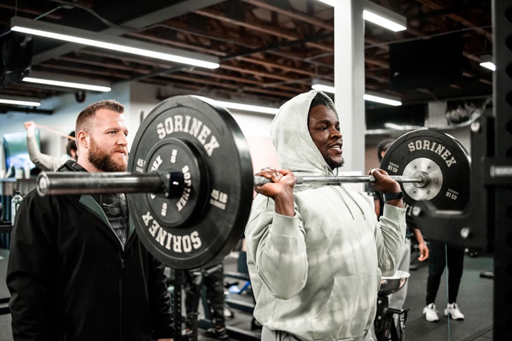 Coach Taylor is helping a client with weights